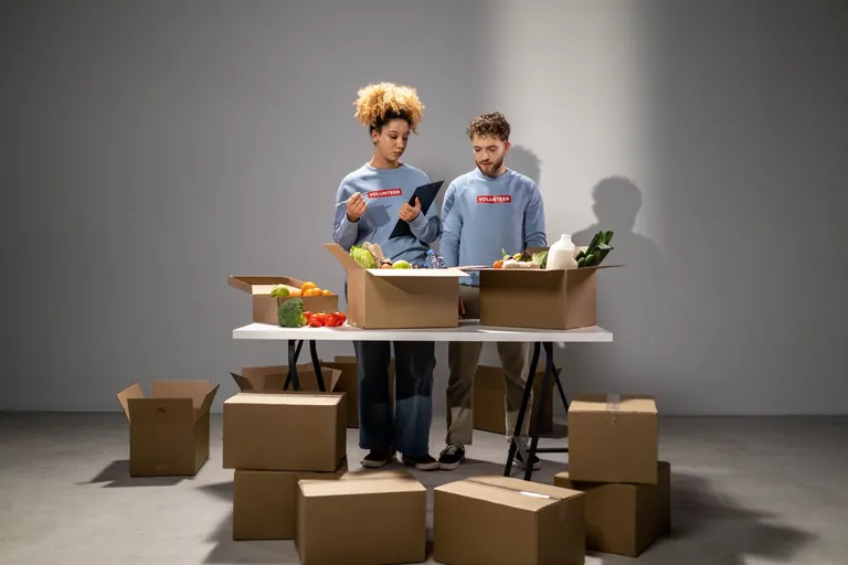 食料品の箱を運ぶボランティアの人々